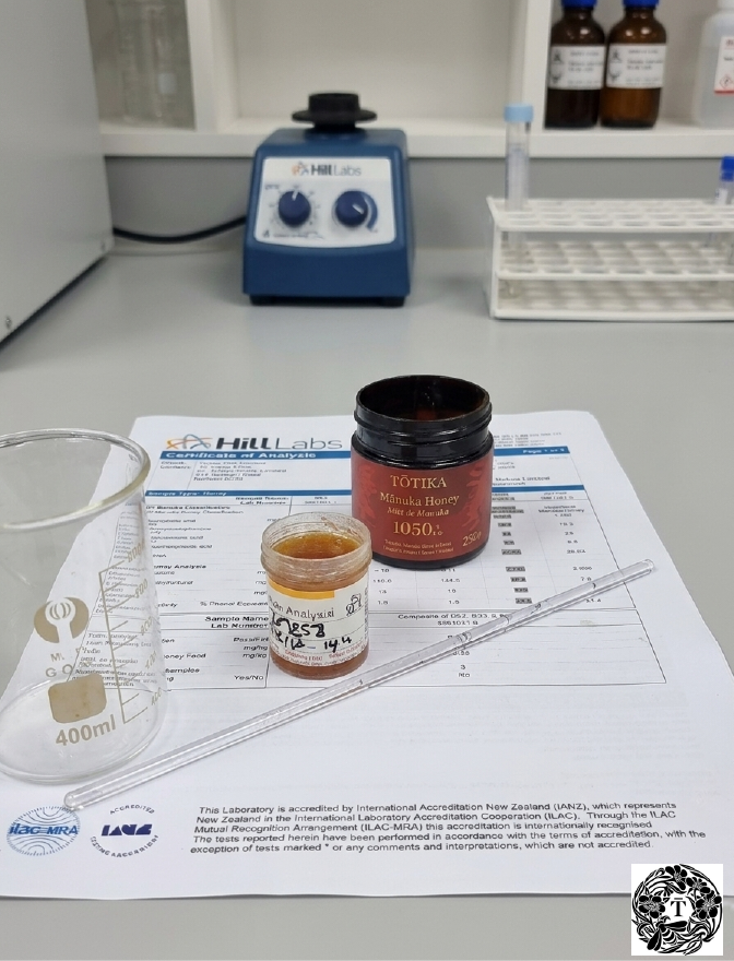 Tōtika MGO 1050+ mānuka honey jar on Hill Laboratories Certificate of Analysis in an IANZ-accredited testing laboratory, New Zealand.